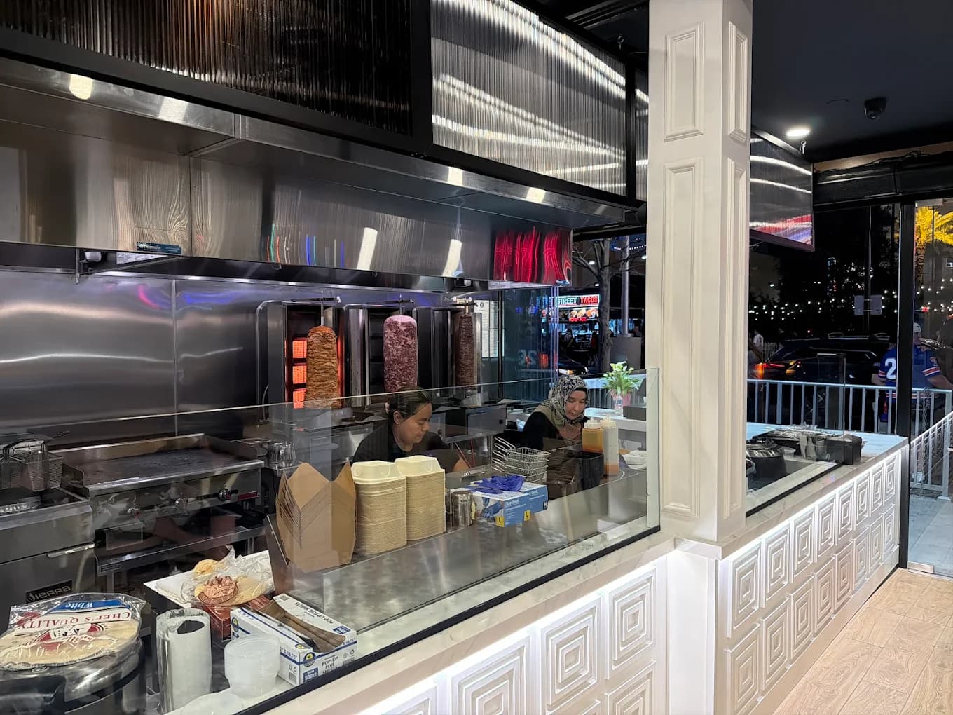 Open kitchen counter with doner kebab spit and guests ordering