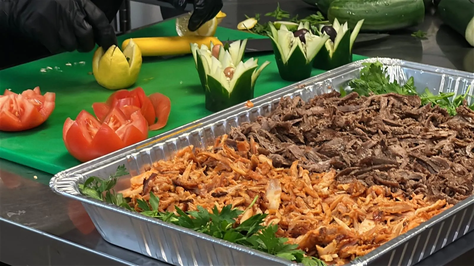 Catering tray of hand-sliced Halal chicken and beef-lamb doner with fresh garnish at Istanbul Mediterranean 2